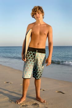 Handsome surfer posing in the beach