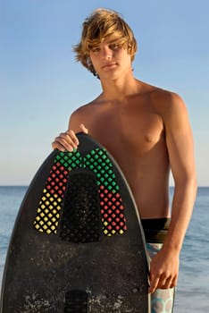 Handsome surfer posing in the beach