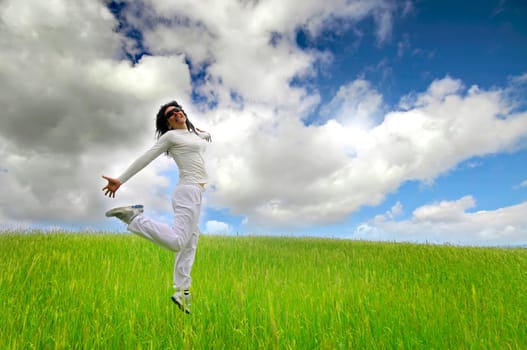Woman jumping high in a green field