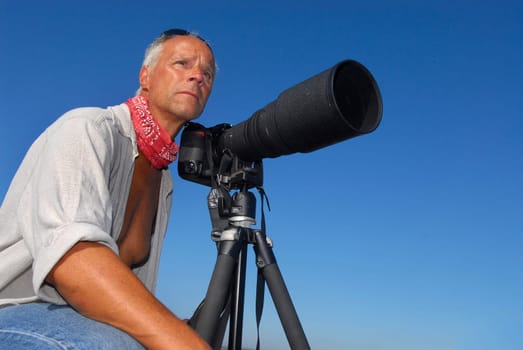 Adventure photographer posing with is camera outdoors