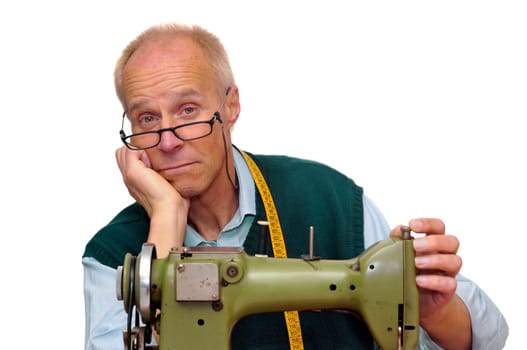 Mature tailor with a sewing machine isolated in white
