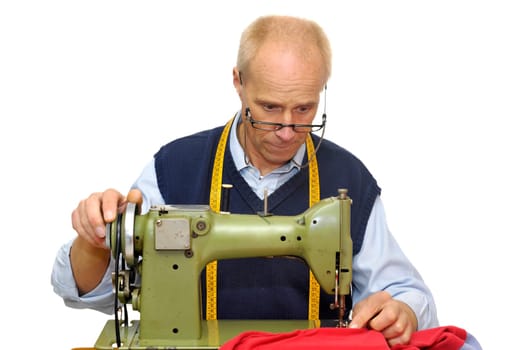 Mature tailor with a sewing machine isolated in white