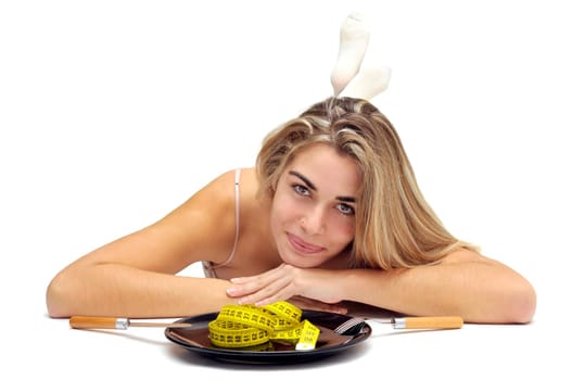 Sexy girl with measuring tape in a dish and no food isolated in white