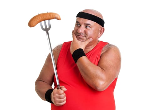 Large fitness man looking at a big sausage isolated in white