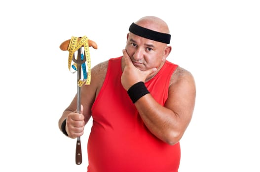 Large fitness man looking at a big sausage isolated in white