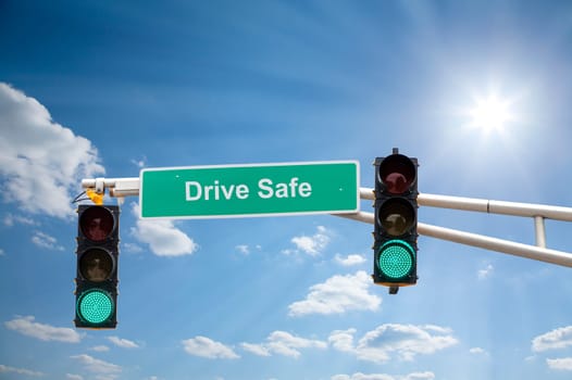 Image of a street sign and traffic lights with blue sunny skies in the background