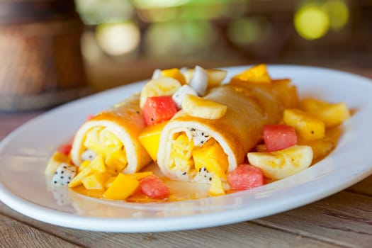 A dish of crepes filled with fresh tropical fruits