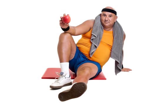 Large fitness man with an apple isolated in white