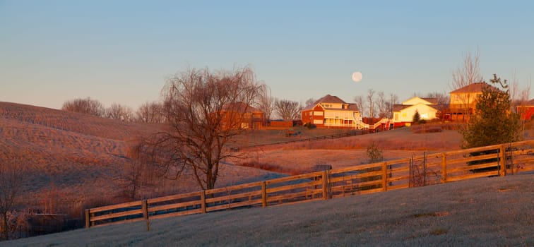 Moon setting over a suburban residential neighborhood