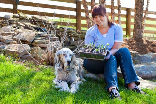 A young woman displays a tray of seedlings for her vegetable garden