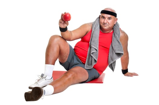 Large fitness man with an apple isolated in white