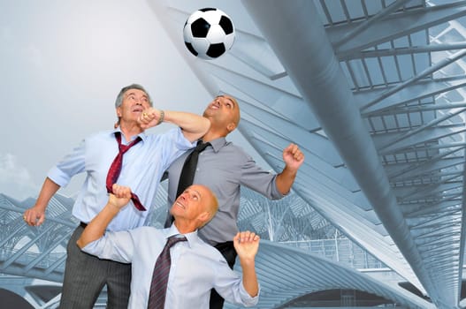 Businessmen playing soccer outdoors
