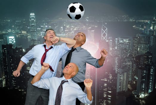 Businessmen playing soccer outdoors