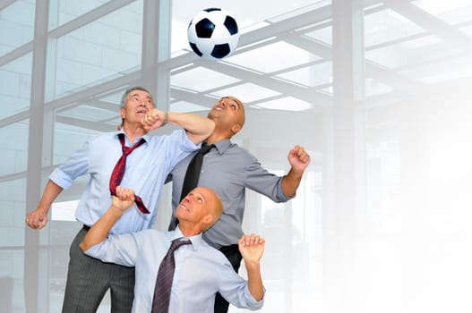 Businessmen playing soccer in the office