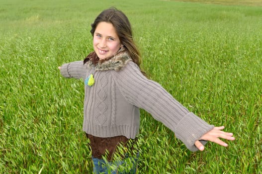 Beautiful young girl outdoors in a green field