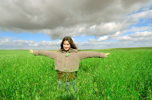 Beautiful young girl outdoors in a green field