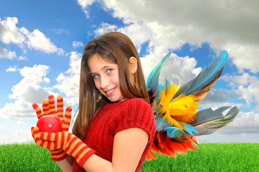 Beautiful girl with apple and wings in a green field
