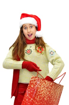 Beautiful young girl with santas hat and shopping bags isolated in white