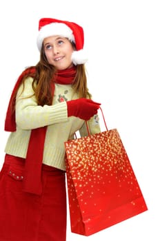 Beautiful young girl with santas hat and shopping bags isolated in white