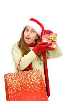 Beautiful young girl with santas hat and shopping bags isolated in white