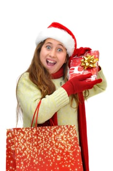 Beautiful young girl with santas hat and shopping bags isolated in white