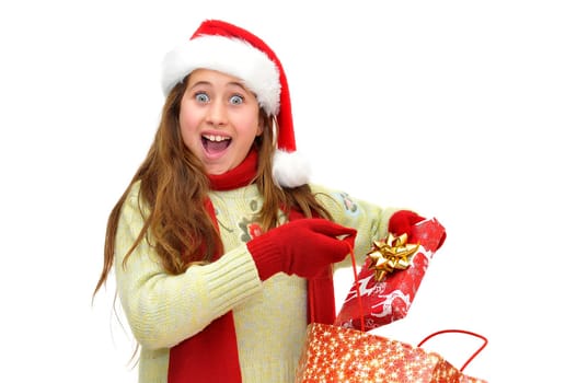 Beautiful young girl with santas hat and shopping bags isolated in white