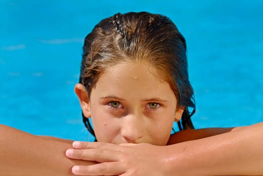 Young girl with green eyes posing in the pool