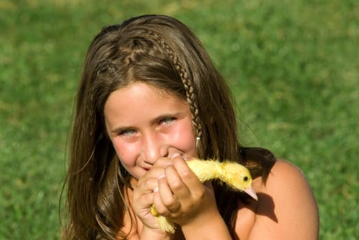 Young girl holding a baby duck, with green background