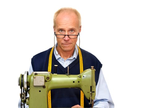 Mature tailor with a sewing machine isolated in white