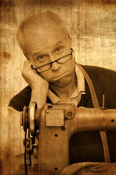 Mature tailor with a sewing machine in old sepia tones