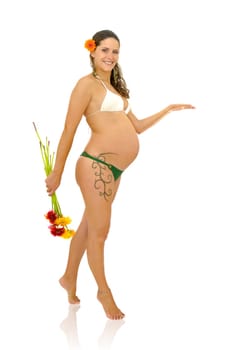Pregnant woman with tattoo in bikini holding a bunch of flowers isolated in white