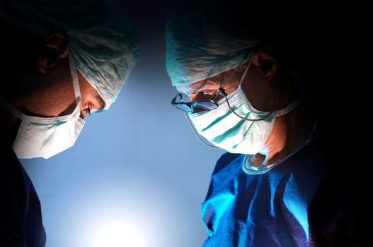 Doctors team in surgery in a dark background