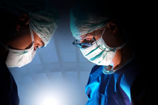 Doctors team in surgery in a dark background