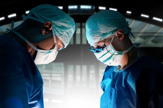 Doctors team in surgery in a dark background