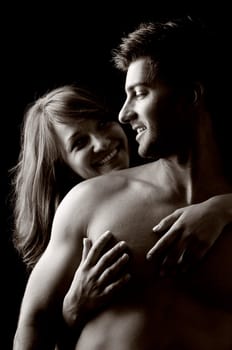 Beautiful fashionable young couple isolated in black