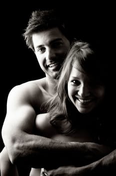 Beautiful fashionable young couple isolated in black