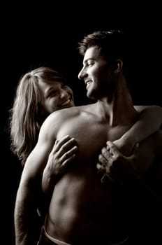 Beautiful fashionable young couple isolated in black