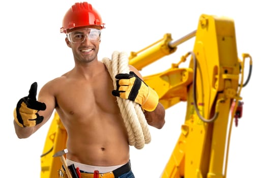 Strong build construction worker with big machine in the background