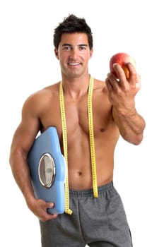Muscular young man with apple and weight scale
