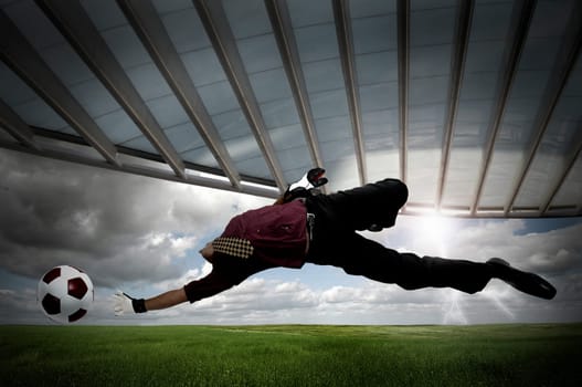 Businessman playing soccer outdoors in a green field