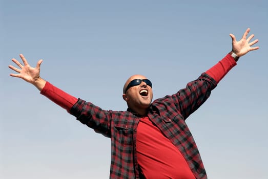 Happy man posing outdoors with sunglasses