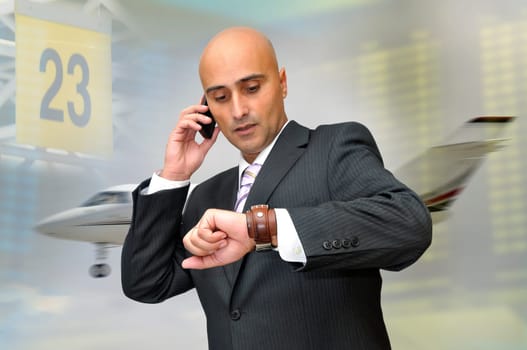 Businessman with cellphone and a jet plane passing behind