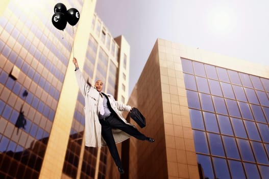 Businessman holding a group of black balloons