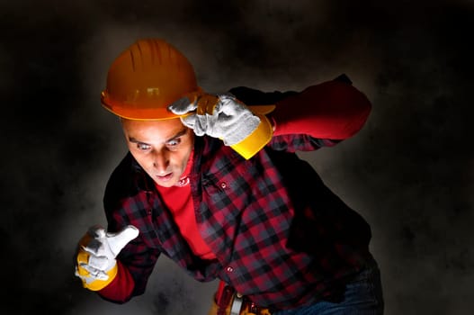 Surprised constructor worker looking at a light in a dark background