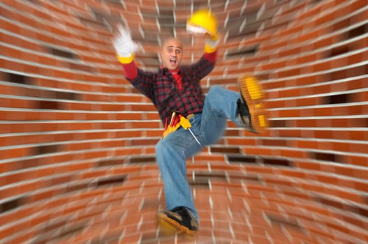 Construction worker falling with a brick wall as background