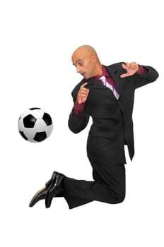 Businessman in a acrobatic pose with a soccer ball isolated in white