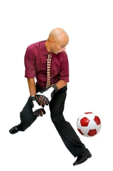 Businessman goalkeeper with gloves trying with no success to stop a ball isolated in white