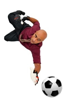 Businessman goalkeeper with gloves and ball in a acrobatic save isolated in white