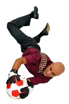 Businessman goalkeeper with gloves and ball in a acrobatic save isolated in white
