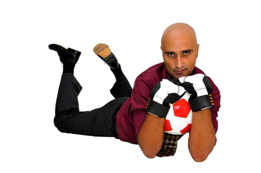 Businessman goalkeeper with gloves and ball in a acrobatic save isolated in white